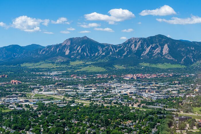 A scenic view of one of the best places to live in the USA with mountains, greenery, and a sprawling cityscape.