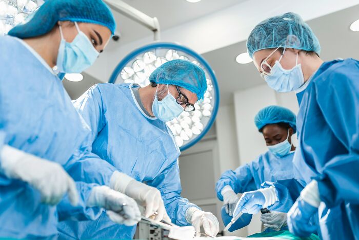 Surgical team in sterile blue gowns and masks performing a critical operation highlighting gut feeling saving lives.