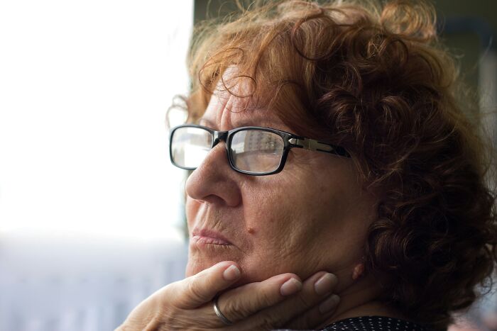 Older woman with glasses looking thoughtful and distressed, reflecting on relationships and married life struggles.