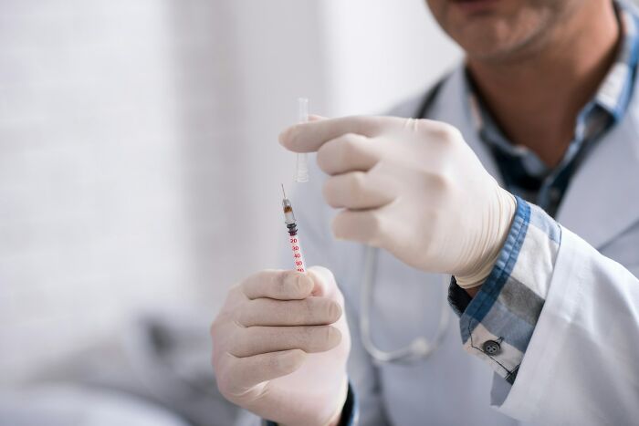Doctor wearing gloves preparing a syringe, related to rare phobias involving needles and medical procedures. - 8