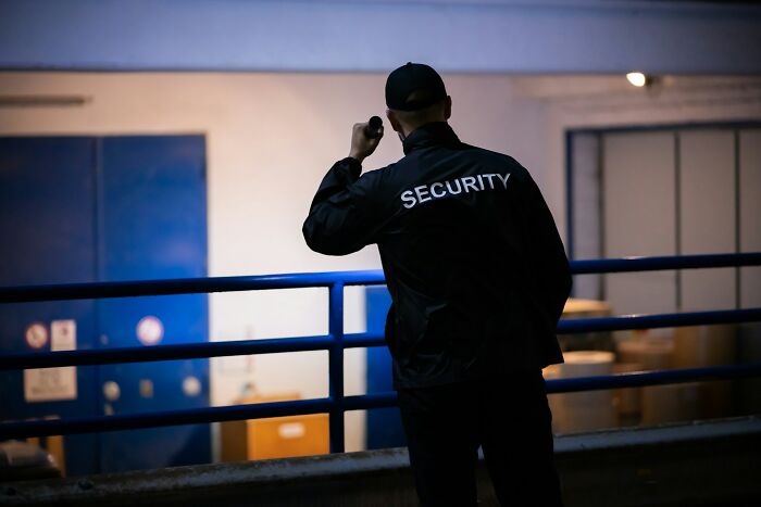 Security guard inspecting a dark area with a flashlight, illustrating vigilance related to pathological liars.