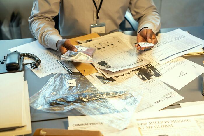 Investigator examining evidence and documents related to cases involving dead bodies and uncovering strange details.