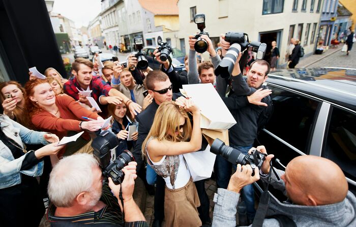 A crowded scene of people with cameras capturing a woman, illustrating normal people's habits some netizens find creepy. - 7