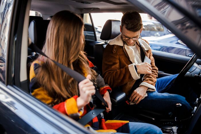 Young man and woman putting on seat belts inside a car, illustrating things non-Americans do that make no sense to Americans - 21