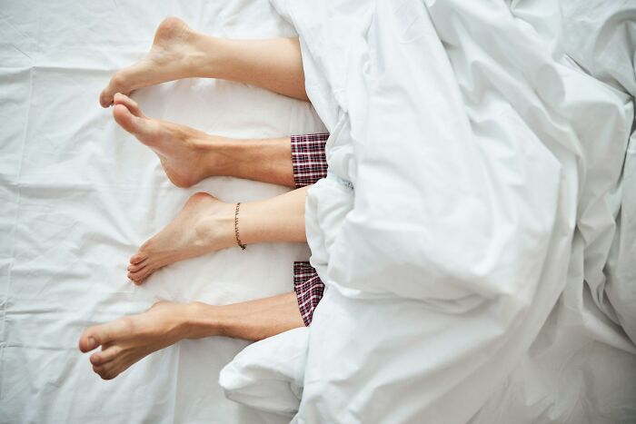 Three pairs of feet sticking out from under white sheets on a bed, illustrating interesting rumors that turned out true.