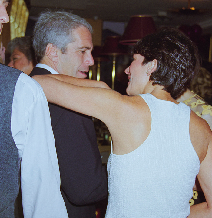 Ghislaine Maxwell and Jeffrey Epstein interacting at a social event with other guests in the background. Ghislaine Maxwell and Jeffrey Epstein interacting at a social event with other guests in the background.