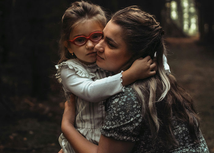 Woman embracing child in forest, symbolizing strength and resilience after ex-husband's new wife failure celebration. - 1