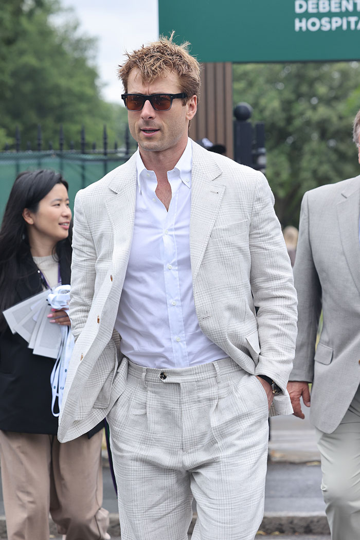 Man wearing a light plaid suit and sunglasses attending Wimbledon 2025, showcasing celebrity looks and fashion styles.