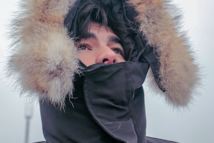 Person bundled in heavy winter clothing with fur-lined hood, illustrating bizarre beliefs about cold weather myths. - 21