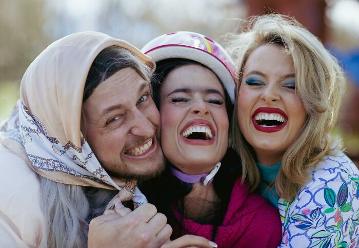 Three friends smiling and laughing together outdoors, showcasing joyful moments and positive green flags in relationships.