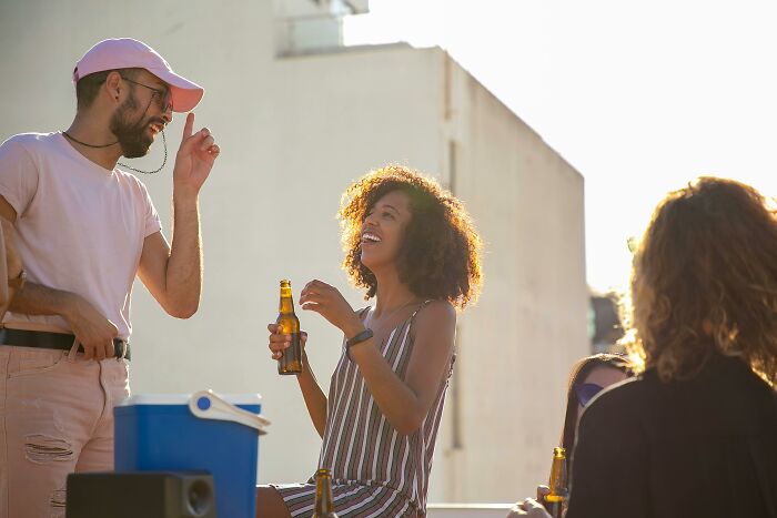 Group of friends enjoying beers outdoors, highlighting green flags in relationships that show someone special.