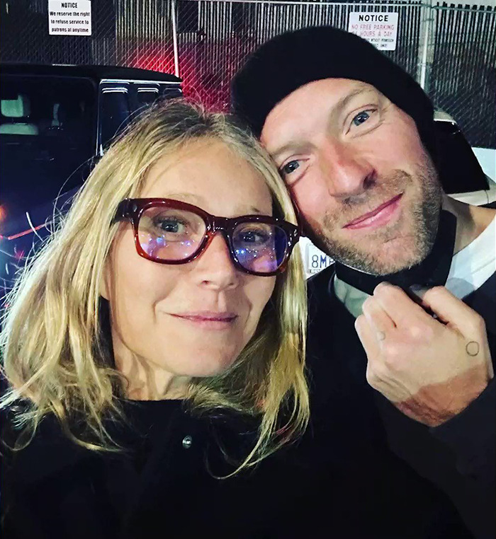 Gwyneth Paltrow close-up selfie with a man wearing a black beanie outside at night near a parking area. - 5