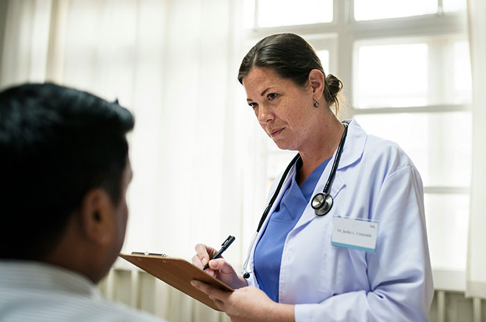 Female doctor with stethoscope consulting patient, illustrating hospital staff sharing wildest things they've witnessed.