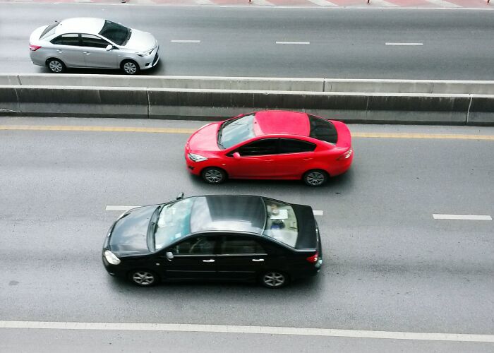 Three cars driving on a multilane road, illustrating normal people's habits some netizens find creepy in traffic behavior. - 13