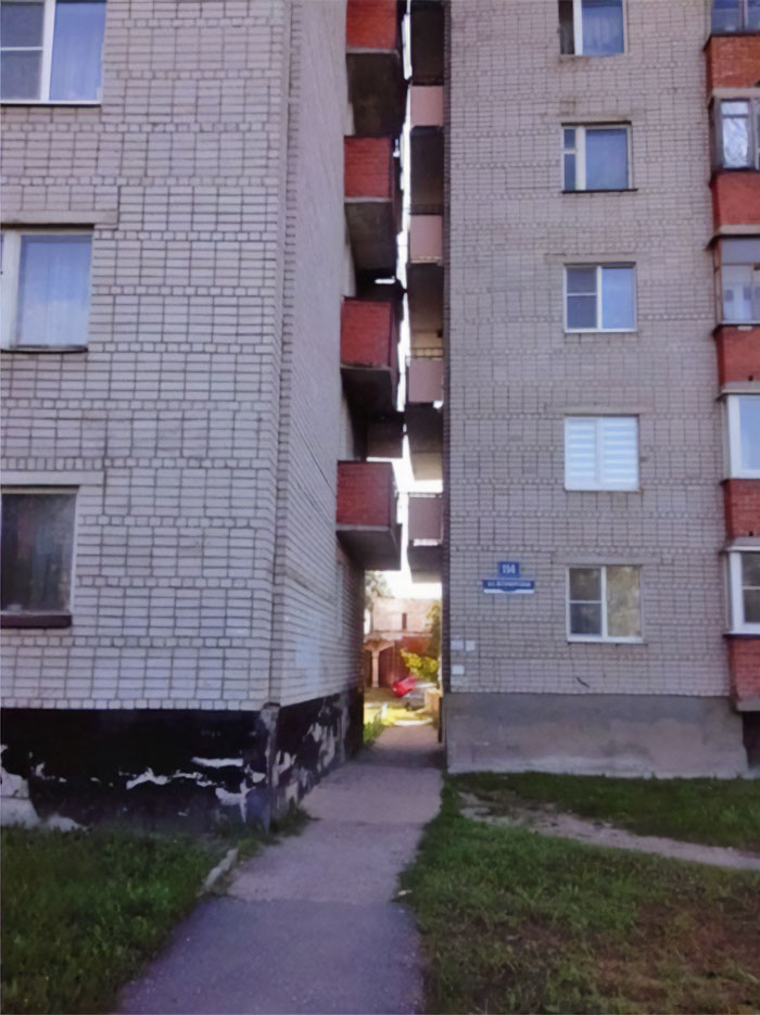 Narrow gap between apartment buildings with small balconies, an example of failed creative home design.