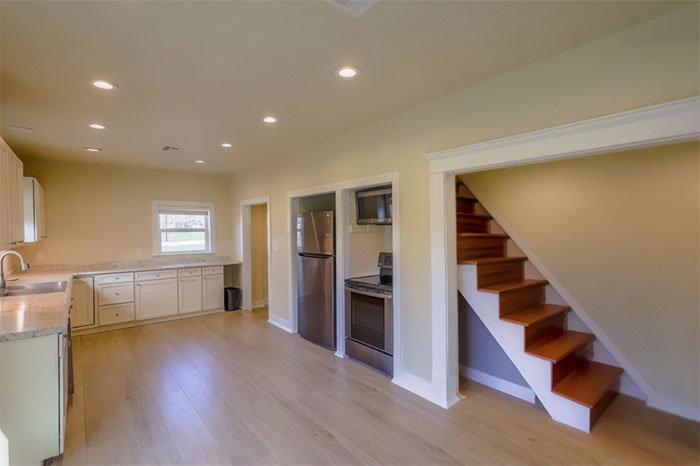 Empty kitchen and wooden stairs showing an example of people who tried to be creative with their homes and failed.