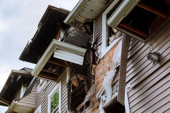 Damaged house exterior showing fire and smoke damage after a narrow escape from disaster due to gut feeling.