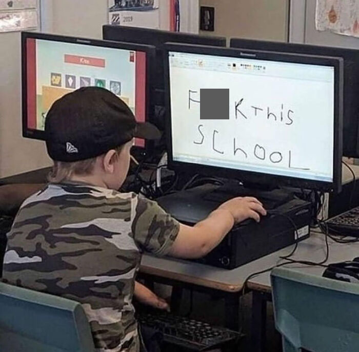 Child in a camouflage shirt at a computer, showing a rebellious message on the screen, capturing unbothered attitude.