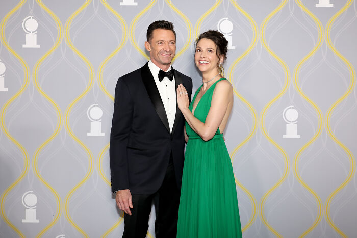 Hugh Jackman and Sutton Foster posing together at an event, dressed formally with bright smiles.