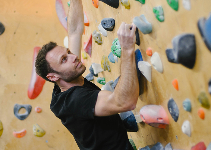 Man focusing on indoor rock climbing, a new hobby causing strain in his marriage according to the concerned mom.
