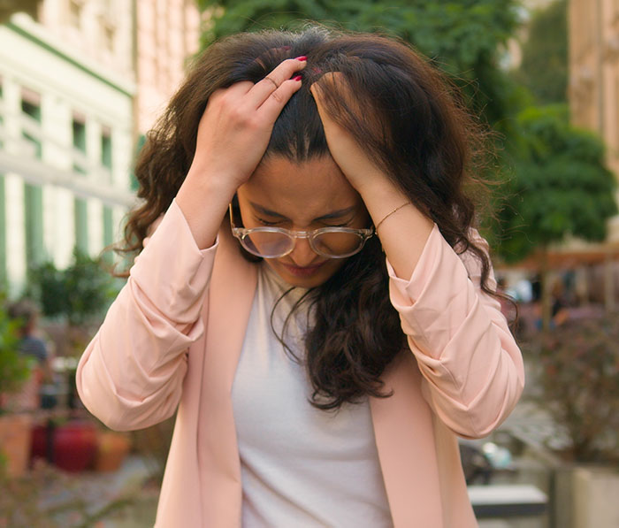 Woman holding her head in frustration outdoors, reflecting the husband jokes wife baby trapped him situation.