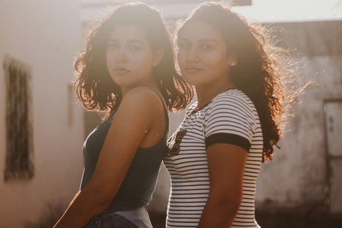 Two students standing outdoors in soft sunlight, representing truly outrageous student names shared by a teacher.