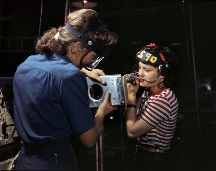 Two women working together in a factory during WWII, showcasing the bold and brilliant world of women at work.