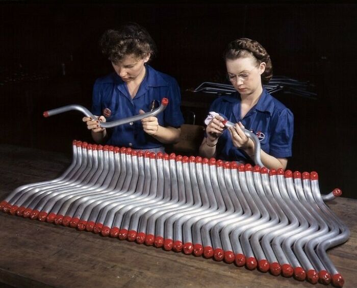 Two women at work during WWII inspecting metal parts, showcasing the bold, brilliant world of women at work in that era.