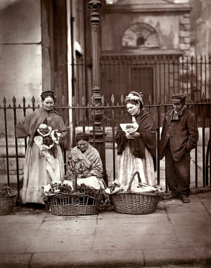 Victorian street vendors selling flowers on a London sidewalk, illustrating how London's poorest lived in the 1800s.
