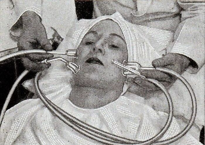 Vintage beauty gadget from the 1920s to 1940s resembling a t*****e device used on a woman's face at a salon.