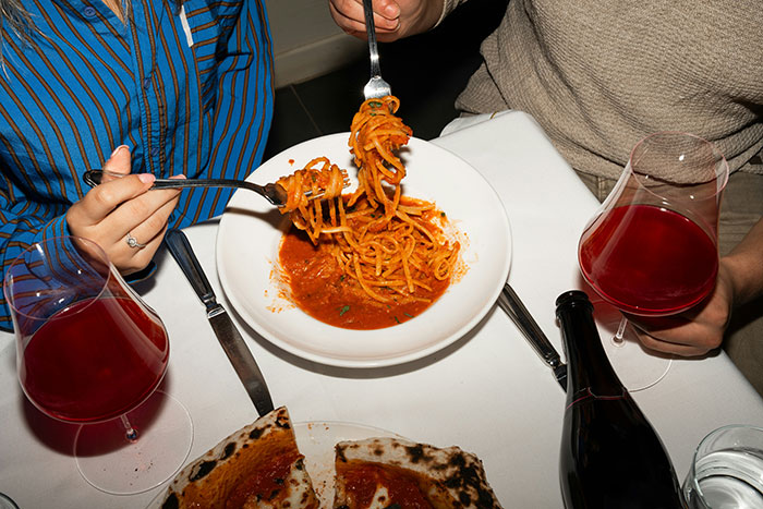 Couple eating pasta and pizza with red wine on table, highlighting inlaws day ruined genetic heritage tension. - 6
