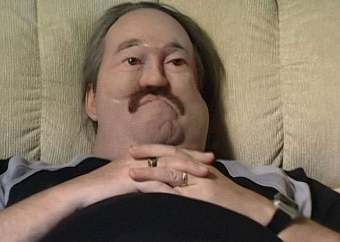 Man with a mustache lying back in a chair, looking scared in a creepy true stories haunting people scene.