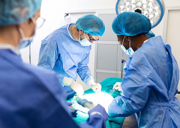 Surgical team in blue scrubs and masks performing an operation under bright lights, evoking creepy true stories atmosphere