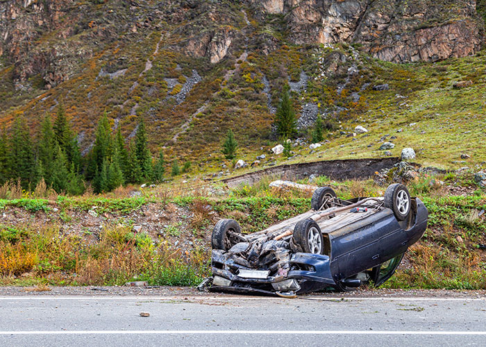 Overturned car on roadside in a remote area, illustrating one of the creepy true stories that haunt people.