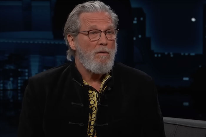 Older man with gray hair and beard wearing glasses and a black jacket sharing awkward celebrity encounters on a talk show. - 3