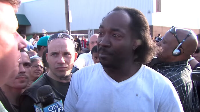Man in white shirt being interviewed during a crowd panic event related to shrinking genitals in Singapore.