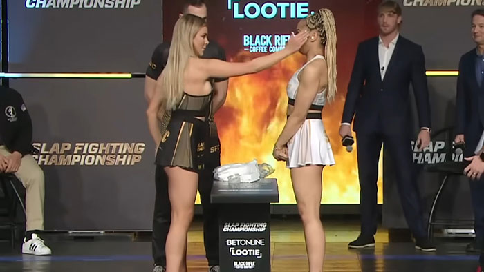 Two women facing off in a slap fighting championship event showcasing intense competition in an indoor arena setting.