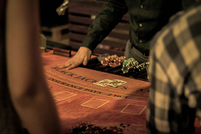 Dealer dealing cards at a blackjack table with poker chips, illustrating cool facts about the world in a casino setting.