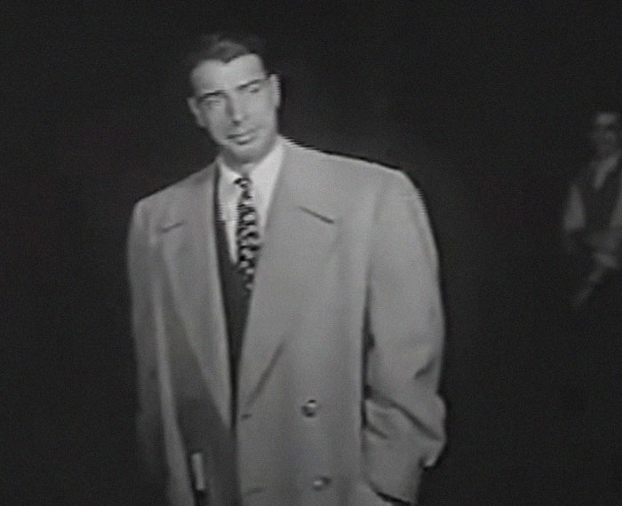 Black and white image of a man in an oversized coat, related to incredibly cool facts about the world.