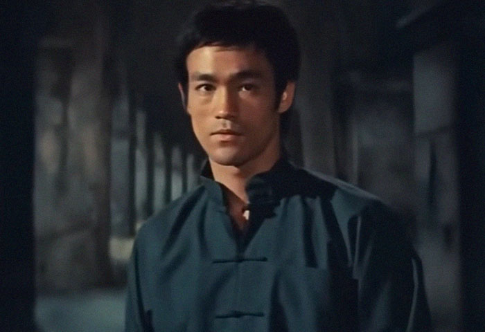 Man in traditional martial arts attire standing in a dimly lit corridor representing world facts theme