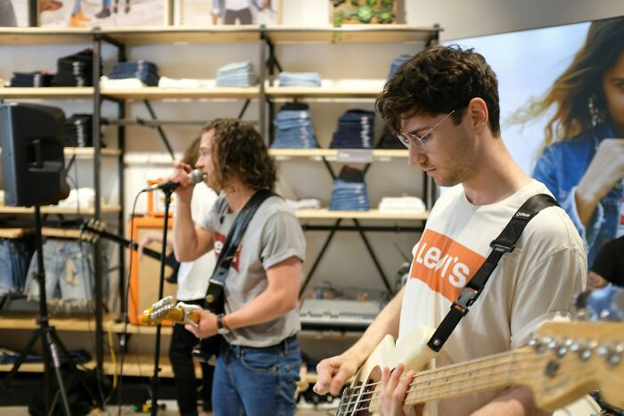 Young musicians playing guitar and singing in a casual indoor setting, focusing on parents punishing kids too far topic.