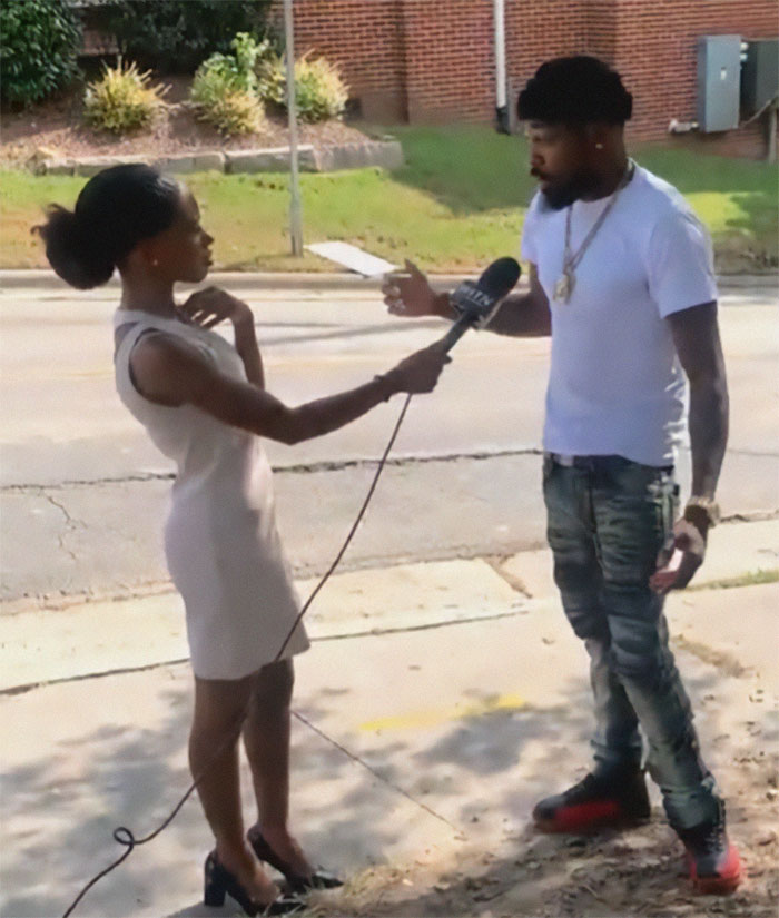 Man warns about sinkhole while reporter holds microphone during street interview about racism and instant karma incident.