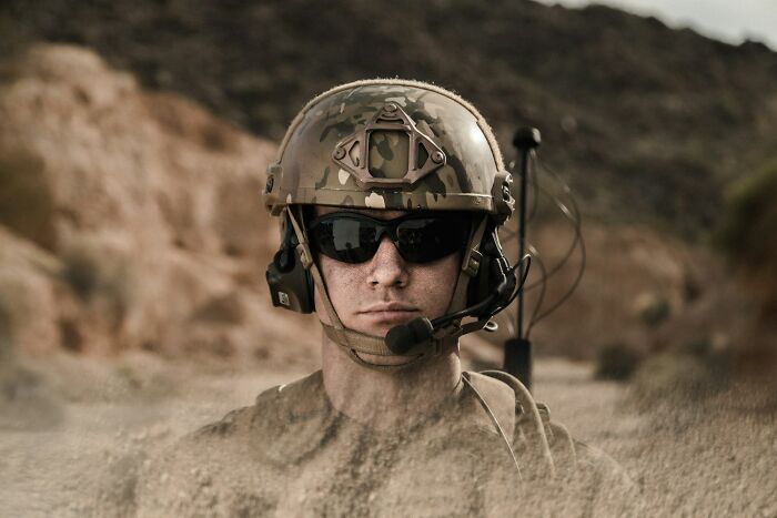 Soldier wearing helmet and sunglasses in a desert landscape, symbolizing trust issues related to pathological liars.