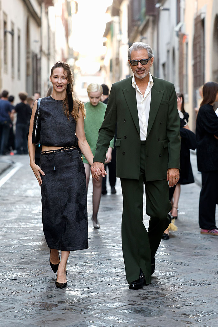Man and woman walking hand in hand on a cobblestone street, showcasing stars you never expected to be super tall.