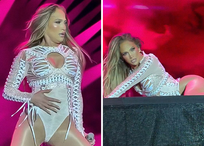 Jennifer Lopez performing on stage in a raunchy show, simulating provocative moves amid vibrant pink lighting.