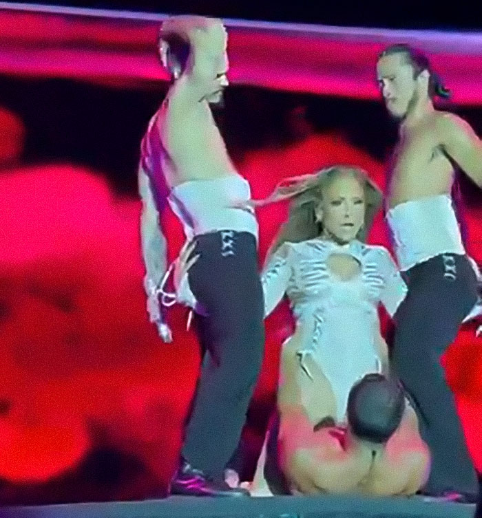 Jennifer Lopez performing raunchy show with dancers, criticized for simulating x-rated moves on stage.