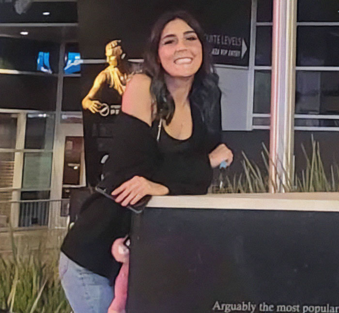 Young woman smiling outdoors near a 7-Eleven statue, related to 7-Eleven worker passes away incident.