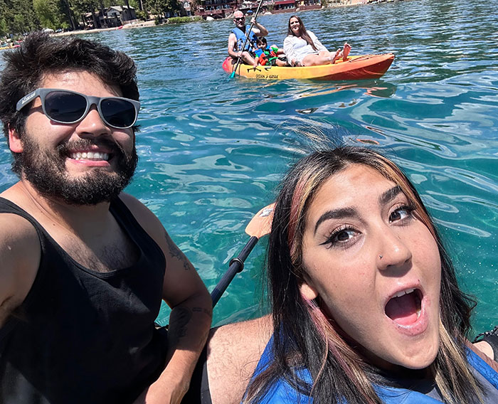 Young people kayaking on clear water with trees in background, unrelated to 7-Eleven worker manager incident news.