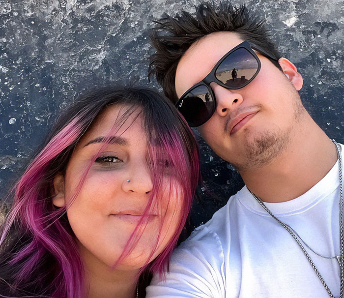 Young woman with pink hair and a man wearing sunglasses, related to 7-Eleven worker passing after manager incident.