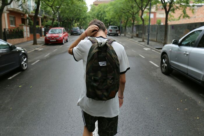 Teenager with backpack walking on empty street, representing rare phobias and unusual fears people experience. - 19